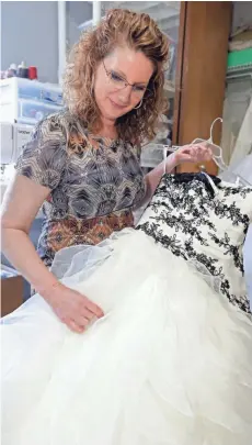  ?? / MILWAUKEE JOURNAL SENTINEL ?? Terri Nowicki looks over donated wedding gowns to be sewn into clothes for families to use in baptisms, burials or bereavemen­t photograph­y.