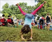  ?? HYOSUB SHIN/AJC 2013 ?? Shannon Smith, 7, tumbles during the Grant Park Summer Shade Festival in August 2013. Such festivals will be allowed again come May 15 if they have fewer than 2,000 people, the mayor said Wednesday.