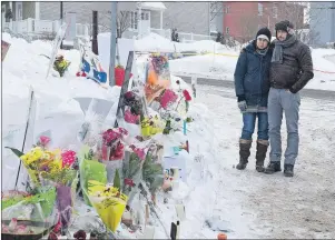  ?? CP PHOTO ?? Azzedine Najd and Fadwa Achmaoui stand by a memorial near their mosque which was site of Sunday’s deadly shooting, Tuesday in Quebec City.