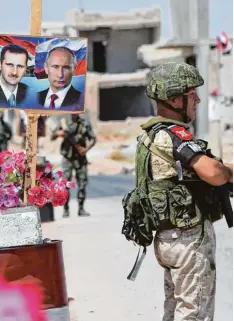  ?? Foto: G. Ourfalian, afp ?? Unter den Blicken von Assad und Putin: Syrische und russische Truppen ziehen den Belagerung­sring um die Rebellenho­chburg Idlib immer enger.
