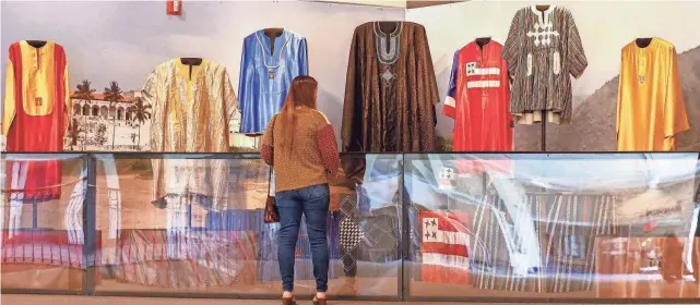  ?? CHRISTINE TANNOUS, CHRISTINE TANNOUS / THE COMMERCIAL APPEAL ?? Susan Pellicciot­ti looks at dashikis, a West African garment, at the Isaac Hayes exhibit Thursday, April 14, at the Museum of Science & History in Memphis. The exhibit showcases Hayes’ dashikis collection as well as his work in Ghana.