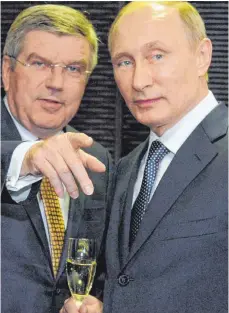  ?? FOTO: DPA ?? Einst enge Verbündete: IOC-Präsident Thomas Bach (li.) und Präsident Wladimir Putin, der das russische Staatsdopi­ng noch immer bestreitet.