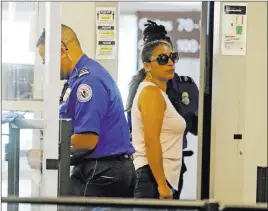  ?? Red Huber ?? The Associated Press Alejandra Juarez, 39, center, passes through TSA screening at the Orlando Internatio­nal Airport on Friday in Orlando, Fla.