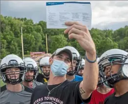  ?? Steph Chambers/Post-Gazette ?? Peters Township quarterbac­ks coach Christian Breisinger goes over a play with the Indians during a recent workout at the school.