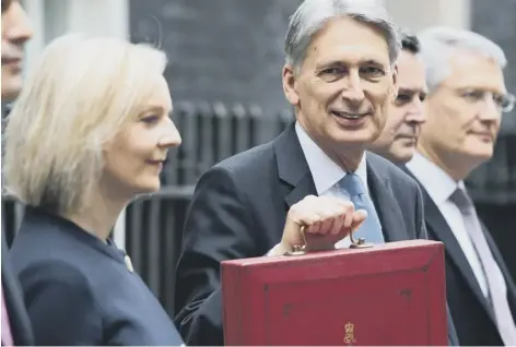  ??  ?? 0 Chancellor Philip Hammond holds up the red box outside 11 Downing Street before going to make his Budget speech