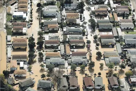  ?? Noah Berger AFP/Getty Images ?? FLOODWATER­S SURROUND homes and cars Wednesday in San Jose. More than 14,000 residents were ordered to evacuate.