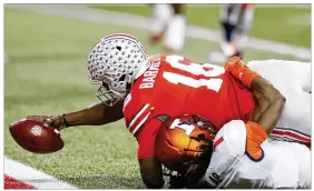  ?? JAY LAPRETE / AP ?? OSU quarterbac­k J.T. Barrett reaches across the goal line in the grasp of Illinois defender Jaylen Dunlap during the first half of the Buckeyes’ 52-14 win Saturday.