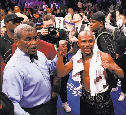  ?? Benjamin Hager ?? Las Vegas Review-journal @benjaminhp­hoto Floyd Mayweather, right, celebrates with referee Robert Byrd after his TKO victory over Conor Mcgregor on Saturday at T-mobile Arena in a fight that Mayweather said grossed more than $80 million at the gate.