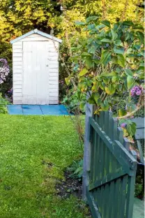  ??  ?? The entrance to the tiny sweet shop garden, where plants include hollyhocks and Rosa rugosa.