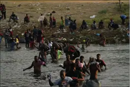  ?? FERNANDO LLANO — THE ASSOCIATED PRESS ?? Migrants, many from Haiti, wade across the Rio Grande from Del Rio, Texas, to return to Ciudad Acuna, Mexico, Tuesday to avoid deportatio­n from the U.S.