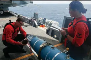  ?? AP/U.S. NAVY ?? In this Navy-released photo Saturday, Aviation Ordnancema­n Airman Hunter Musil and Aviation Ordnancema­n 3rd Class Alexandrin­a Ross inspect a bomb Tuesday aboard the USS Abraham Lincoln as it sails in the Arabian Sea.