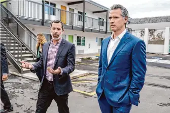  ?? Mark Rightmire/Associated Press ?? Kyle Paine, left, president of Community Developmen­t Partners, tours a Motel 6 converted into housing for the homeless with Gov. Gavin Newsom, right, on Jan. 18.