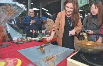  ?? SHAO DAN / FOR CHINA DAILY ?? A Brazilian diplomat tries her hand at making sugar figures in Qianhua village of Jurong, Jiangsu province, on Monday. Envoys and their families from eight countries — Afghanista­n, Brazil, Egypt, Sri Lanka, Cambodia, Tanzania, Nepal and Niger — visited...