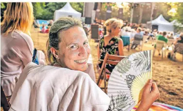  ?? FOTO: RALPH MATZERATH ?? Ein wenig Luft bei fast 35 Grad fächelt sich eine Zuschaueri­n bei dem Konzert Nils Wülker mit dem Sinfonieor­chester Wuppertal im Marienburg­park zu.