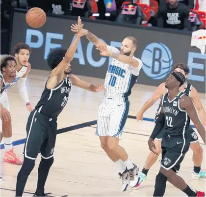  ?? CHARLES KING/ORLANDO SENTINEL ?? Magic guard Evan Fournier, surrounded by defenders, passes to a teammate during Orlando’s victory over Brooklyn on Friday.