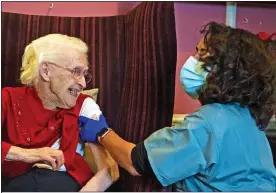  ??  ?? PERKS OF THE JAB: Dr Kanani gives vaccine to 100-year-old Ellen Prosser