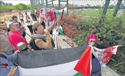  ??  ?? PROTESTAS. Varios palestinos acudieron al entrenamie­nto de Argentina con camisetas ensangrend­atas pidiendo la suspensión del partido..