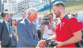  ??  ?? Prince Charles presents Owen Lane with his cap.