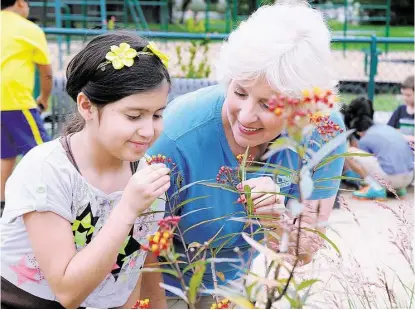  ?? David Hopper ?? Garden Club member Fanny Amaya and school nurse Linda Rosemeyer examine a flower at the educationa­l garden at Klein Independen­t School District’s Greenwood Elementary School, 12100 Misty Valley Drive in Houston.