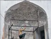  ?? BURHAAN KINU/HT ?? A worker cleans the mural adorning the roof of Chhatta bazaar, situated inside the Red Fort.