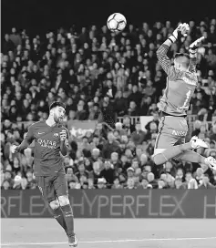  ?? — Reuters photo ?? Barcelona’s Lionel Messi heads the ball to score against Sporting Gijon goalkeeper Cuellar.