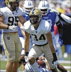  ?? BEN MARGOT/AP 2021 ?? Army linebacker Andre Carter II (center) celebrates after sacking Georgia State’s Cornelious Brown IV on Sept. 4 in Atlanta. At 6 feet 7 and 250 pounds, Carter leads the nation with 1.32 sacks per game and has 14.5 in 11 games, 13 of them solo.