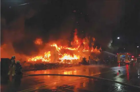  ?? ?? Firefighte­rs battle the blaze that tore through a building in the southern Taiwanese city of Kaohsiung.