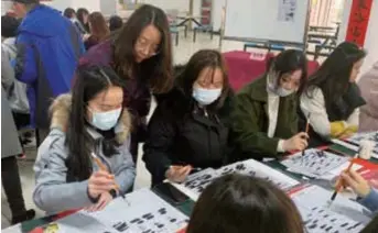  ??  ?? Students at Shanghai Vocational College of Science and Technology who stayed put in Jiading because of COVID-19 practice calligraph­y together during the Spring Festival. — Bu Yu