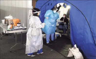  ?? Ned Gerard / Hearst Connecticu­t Media ?? Medical personnel conduct the daily drive-thru COVID-19 testing at Bridgeport Hospital on Dec. 9.