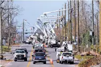  ?? GERALD HERBERT/ASSOCIATED PRESS ?? Utility crews set up new poles and utility wires Thursday in the aftermath of Hurricane Michael in Panama City, Fla. More than a week after Hurricane Michael smashed into the Florida Panhandle on a path of destructio­n that led all the way to the Georgia border and beyond, more than 100,000 Florida customers are still without power.