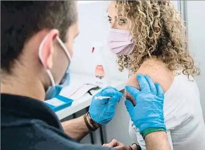  ?? BERTRAND GUAY / AFP ?? Una joven recibe una vacuna de Pfizer en el centro La Defense, en París