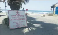  ?? (Ben Hartman) ?? A MULTILINGU­AL sign forbids beachgoers from bathing at Metzitzim Beach in Tel Aviv yesterday.