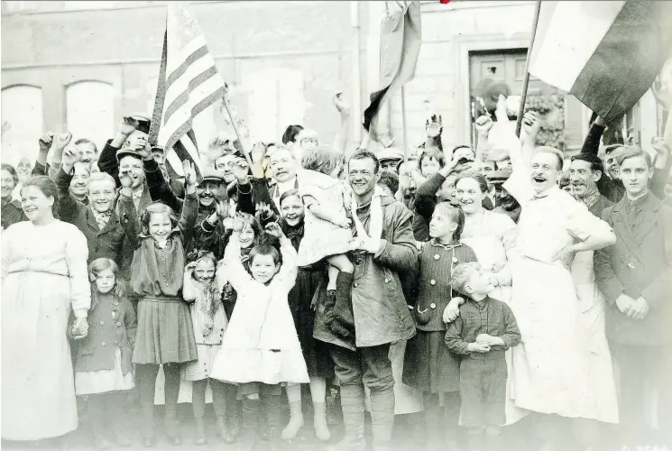  ?? GEORGE METCALF ARCHIVAL COLLECTION © CANADIAN WAR MUSEUM ?? Residents of liberated French town of Valencienn­es welcome Canadian troops in November 1918, just days before the armistice was signed to end the First World War.