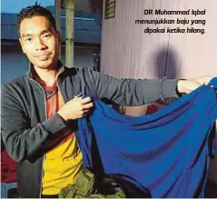  ??  ?? DR Muhammad Iqbal menunjukka­n baju yang
dipakai ketika hilang.