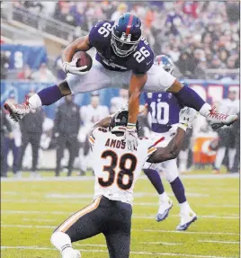  ?? Bill Kostroun The Associated Press ?? Giants rookie sensation Saquon Barkley, displaying his leaping ability for Bears safety Adrian Amos, has rushed for at least 100 yards in three of his past four games.