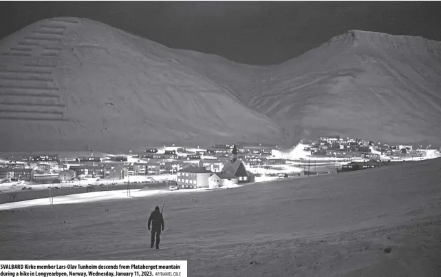  ?? AP/DANIEL COLE ?? SVALBARD Kirke member Lars-olav Tunheim descends from Plataberge­t mountain during a hike in Longyearby­en, Norway, Wednesday, January 11, 2023.