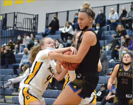  ?? PHOTOS BY MATTHEW MOWERY — FOR MEDIANEWS GROUP ?? Clarkston’s Izzy Hadley (4) tries to pull the ball away from Birmingham Marian’s Sarah Sylvester in the first half of the season opener between the two teams on Monday. Marian held on to win, 54-48.
