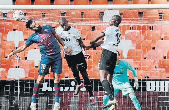  ?? FOTO: EFE ?? KOndogbia y Diakhaby intentan evitar un remate de Siovas, autor del gol del Huesca en Mestalla. El Valencia mostró su peor imagen y solo pudo amarrar un punto ante los oscenses