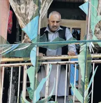  ?? PHOTO: REUTERS ?? Shattered . . . An Afghan man looks outside through a broken window at the site of a suicide attack in Kabul yesterday.