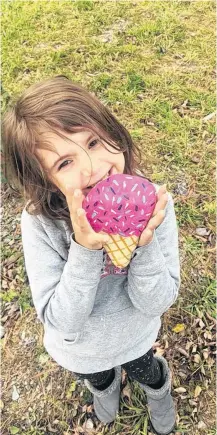  ??  ?? Olivia Clarke shows off the ice cream painted rock she found made by the Shelburne NS Rocks group.