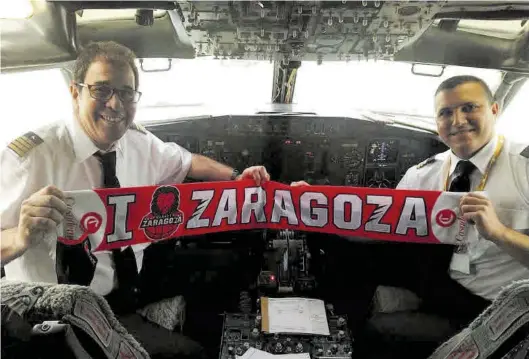  ?? CASADEMONT ZARAGOZA ?? Los pilotos del avión que trasladaro­n al equipo desde Zaragoza, junto a las plantillas de Burgos y Tenerife, posan con la bufanda.