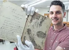  ?? Picture: PA. ?? Chris Baker of Gardiner Houlgate auctioneer­s, holds one of Frederick Allen’s journals.