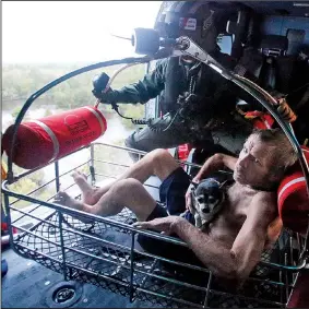  ?? AP/STEVE HELBER ?? Willie Schubert is hoisted aboard a U.S. Coast Guard helicopter as he is rescued off a stranded van Monday in Pollocksvi­lle, N.C.