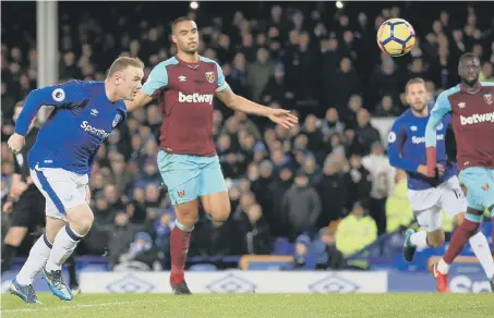  ??  ?? Wayne Rooney heads in Everton’s opener after his penalty was saved by Joe Hart at Goodison last night