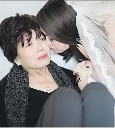  ?? MASON NEUFELD PHOTOGRAPH­Y ?? Wearing a wedding dress, Lexi Verge kisses her mother Wendy at Victoria Hospital in Prince Albert.