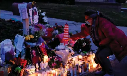  ?? Photograph: Keith Birmingham/AP ?? A woman places a flag at a makeshift memorial for Bishop David O’Connell.