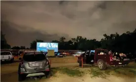  ?? Photograph: Vic Micolucci/AFP via Getty Images ?? People enjoy a movie from their cars, separated from other cars by a 10ft orange fencing to respect social distancing at the Ocala drive-in theatre in Florida at the weekend.