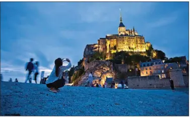  ?? (Rick Steves) ?? Christian pilgrims and tourists are drawn to the dramatical­ly situated Mont St-Michel, a soaring island abbey in Normandy that is completely surrounded by the sea at high tide.