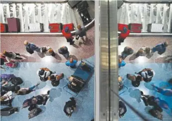  ?? John Locher, The Associated Press ?? Passengers wait for baggage at Mccarran Internatio­nal Airport in Las Vegas in June.