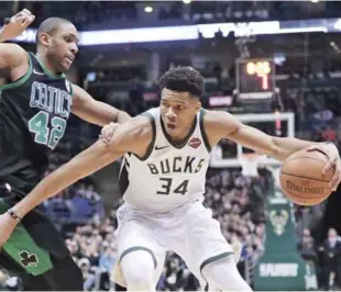  ?? AP ?? Giannis Antetokoun­mpo, de los Bucks de Milwaukee, trata de evadir la defensa de Al Horford, de los Celtics de Boston, durante la primera mitad del cuarto partido de la serie de primera ronda de los playoffs de la Conferenci­a del Este de la NBA.